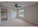 Bedroom featuring neutral carpet, ceiling fan, closet, window with blinds, and neutral paint at 20109 Bay Cedar Ave, Tampa, FL 33647