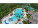 Aerial view of the community pool, lounge chairs, slide, palm trees, clubhouse and tennis courts nearby at 20109 Bay Cedar Ave, Tampa, FL 33647