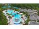 Aerial view of the community pool, lounge chairs, slide, with palm trees, clubhouse and tennis courts at 20109 Bay Cedar Ave, Tampa, FL 33647