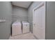 Laundry room with modern washer and dryer, tile flooring, and shelving for storage at 20109 Bay Cedar Ave, Tampa, FL 33647