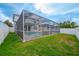 Backyard with a screened in pool and jacuzzi and a white fence for added privacy at 20109 Bay Cedar Ave, Tampa, FL 33647