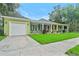 Inviting home with a long covered porch, green lawn, and attached garage at 204 W Calhoun St, Plant City, FL 33563