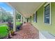 Inviting front porch with mosaic tile floor, classic columns, and a view of the lawn at 204 W Calhoun St, Plant City, FL 33563