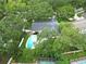 Aerial view of a home with a backyard pool surrounded by lush greenery and mature trees at 2273 Willowbrook Dr, Clearwater, FL 33764