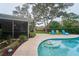 Private backyard oasis featuring a swimming pool, lounge chairs, lush landscaping, and patio at 2273 Willowbrook Dr, Clearwater, FL 33764