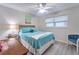 Light-filled bedroom with a ceiling fan, neutral walls, and a comfortable bed with blue bedding at 2273 Willowbrook Dr, Clearwater, FL 33764