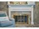 Stone fireplace with a white mantle decorated with candles, plants, and a gray armchair with pillows at 2273 Willowbrook Dr, Clearwater, FL 33764