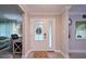 Bright foyer featuring a glass-paneled door, light wood floors, and neutral walls at 2273 Willowbrook Dr, Clearwater, FL 33764