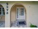 Close-up of the front door framed by elegant arches and decorative landscaping at 2273 Willowbrook Dr, Clearwater, FL 33764