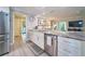 Bright kitchen with stainless steel dishwasher and sink, white cabinets, and granite countertops at 2273 Willowbrook Dr, Clearwater, FL 33764