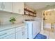 Well-organized laundry room with white cabinetry, washer, dryer, shelves, and tiled flooring at 2273 Willowbrook Dr, Clearwater, FL 33764