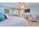 Bright main bedroom with a ceiling fan, tv, access to the outside, light blue walls, and wood-look flooring at 2273 Willowbrook Dr, Clearwater, FL 33764