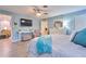 Bright main bedroom with a ceiling fan, tv, walk in closet, light blue walls, and wood-look flooring at 2273 Willowbrook Dr, Clearwater, FL 33764