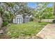 Spacious backyard with two storage sheds, lush grass, and mature trees at 2526 W Jean St, Tampa, FL 33614