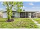 The backyard features a screened patio, a well-manicured lawn, and stepping stones at 2526 W Jean St, Tampa, FL 33614