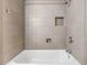 Modern bathtub with neutral-toned tiled walls and built-in shower niche at 2526 W Jean St, Tampa, FL 33614