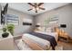 Bedroom with a bed, ceiling fan, bedside tables and lamps, and a large window at 2526 W Jean St, Tampa, FL 33614