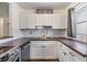 U-shaped kitchen with white cabinets, tile backsplash, and modern fixtures at 2526 W Jean St, Tampa, FL 33614