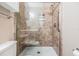Luxurious tiled shower with built-in shelves, glass door, and convenient grab bar at 2526 W Jean St, Tampa, FL 33614