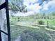 View of a lake from a screened-in lanai with lush greenery surrounding the water at 2625 State Road 590 # 1012, Clearwater, FL 33759
