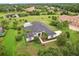 An aerial view of a well-maintained residence featuring a screened-in pool area amidst lush green landscaping at 2708 Coastal Range Way, Lutz, FL 33559