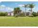 Lush backyard features a well-maintained lawn, palm trees, and view of screened pool area at 2708 Coastal Range Way, Lutz, FL 33559