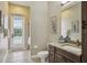 Bathroom with granite countertops, framed mirror, and a walk-out door to screened outdoor area at 2708 Coastal Range Way, Lutz, FL 33559