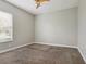 Spacious bedroom featuring carpet, a ceiling fan and a bright window at 2708 Coastal Range Way, Lutz, FL 33559