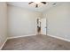 Neutral-toned bedroom featuring carpet and ceiling fan, leading to the en-suite bathroom for convenience at 2708 Coastal Range Way, Lutz, FL 33559