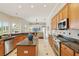 Gourmet kitchen features stainless appliances, granite counters, light wood cabinets and breakfast bar at 2708 Coastal Range Way, Lutz, FL 33559