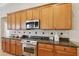 Well-lit kitchen features stainless steel appliances, granite counters, and custom wood cabinets at 2708 Coastal Range Way, Lutz, FL 33559