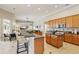 Open-concept kitchen with island breakfast bar overlooks a living room with large picture windows at 2708 Coastal Range Way, Lutz, FL 33559