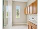 Bright laundry room with extra window light, overhead wood cabinets, and tile flooring at 2708 Coastal Range Way, Lutz, FL 33559