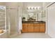 Spacious bathroom with glass shower, wood cabinetry, and large vanity mirror offering lots of counter space at 2708 Coastal Range Way, Lutz, FL 33559