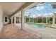 Outdoor pool with screened enclosure, open view of manicured yard, ceiling fans, and brick floors at 2708 Coastal Range Way, Lutz, FL 33559