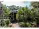 Backyard of house featuring tropical plants and brick pathway at 272 Orange St, Palm Harbor, FL 34683
