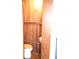Small bathroom with wood paneled walls and basic toilet at 272 Orange St, Palm Harbor, FL 34683