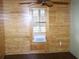 Bedroom featuring wood walls, wood floors, window, blinds, and ceiling fan at 272 Orange St, Palm Harbor, FL 34683
