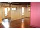 Inviting living room with hardwood floors, wood paneling, and multiple windows at 272 Orange St, Palm Harbor, FL 34683