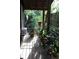 Outdoor porch with wooden floors and walls and ornate iron railings overlooking lush yard at 272 Orange St, Palm Harbor, FL 34683