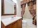 Bathroom featuring framed mirror, wood cabinets, and an adjacent tub and shower combo at 27511 Hialeah Way, Wesley Chapel, FL 33544