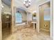 Luxurious bathroom with a soaking tub, walk-in shower, and a pedestal sink with decorative mirror at 27511 Hialeah Way, Wesley Chapel, FL 33544