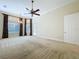 Large bedroom with high ceilings, neutral carpeting, and custom draperies letting in ample natural light at 27511 Hialeah Way, Wesley Chapel, FL 33544