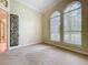 Bedroom with neutral carpeting, ample natural light, and a decorative doorway to another room at 27511 Hialeah Way, Wesley Chapel, FL 33544