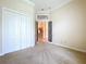 A bedroom with neutral carpeting, a double closet, and a decorative doorway leading to the rest of the house at 27511 Hialeah Way, Wesley Chapel, FL 33544