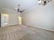 Spacious bedroom with high ceilings, neutral carpet, ceiling fan, and an ensuite bathroom at 27511 Hialeah Way, Wesley Chapel, FL 33544