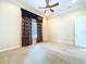 Spacious bedroom features a ceiling fan, a window dressed with drapes, and neutral carpet at 27511 Hialeah Way, Wesley Chapel, FL 33544