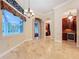 Elegant dining room with travertine floors, decorative windows, and chandelier, bathed in natural light at 27511 Hialeah Way, Wesley Chapel, FL 33544