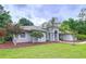 A gray single-story home with a manicured lawn, a circular driveway, and mature landscaping at 27511 Hialeah Way, Wesley Chapel, FL 33544