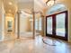 A bright and open foyer with travertine floors, decorative ceilings, and elegant columns at 27511 Hialeah Way, Wesley Chapel, FL 33544
